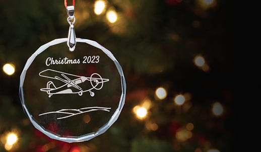 sporty's 2023 christmas ornament in front of tree and lights in the background