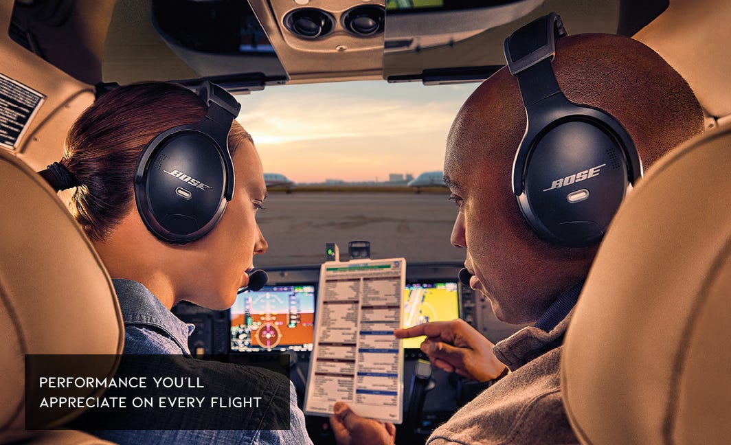 Two pilots wearing Bose A30 headsets in cockpit communicating