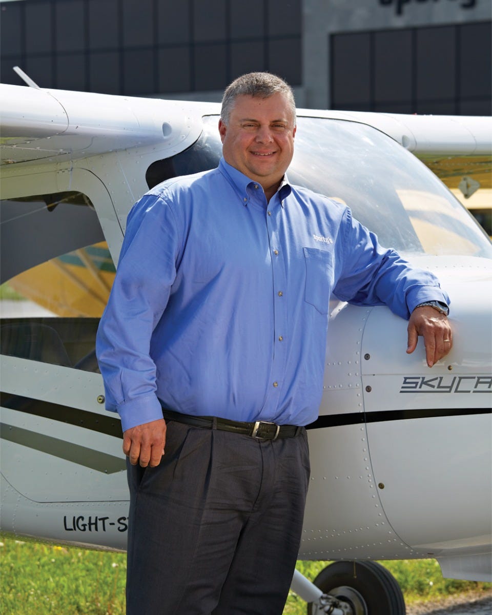 Chuck Gallagher standing outside in front of wing of aircraft