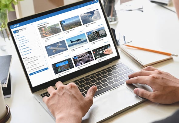 Someone on a laptop with online course menus showing
