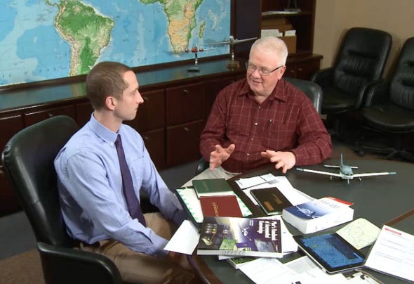 Two men at a conference table having a discussion
