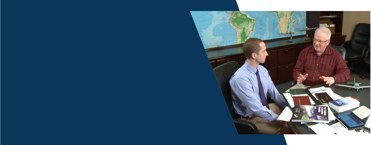 Two men at a conference table having a discussion