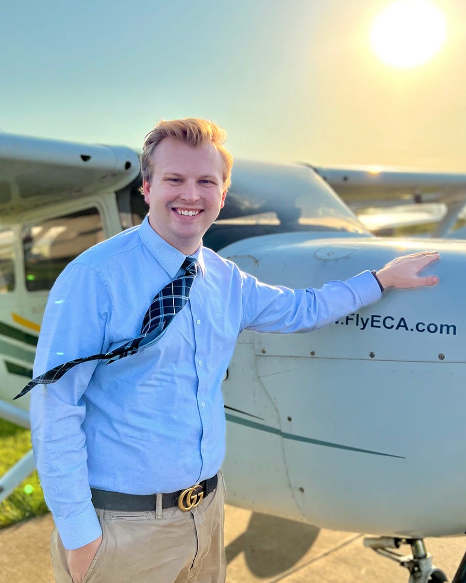 Noah Frye staning next to a airplane.