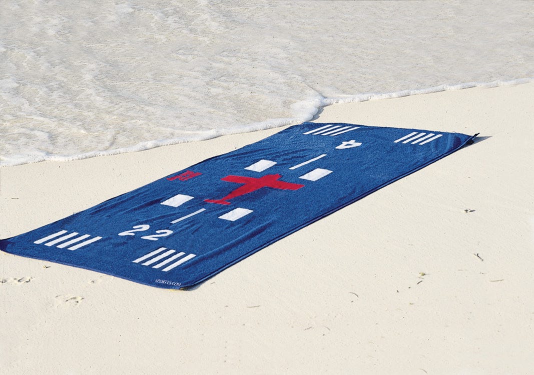 blue aviation themed beach towel on beach