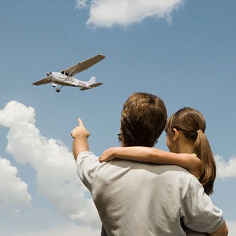 Father's Day Gift guide - photo of Father and daughter looking at plane landing