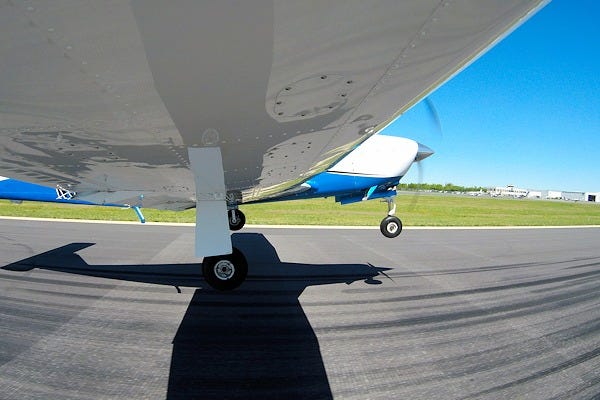 Close-up view of a pilot's feet on the rudder pedals of a small aircraft